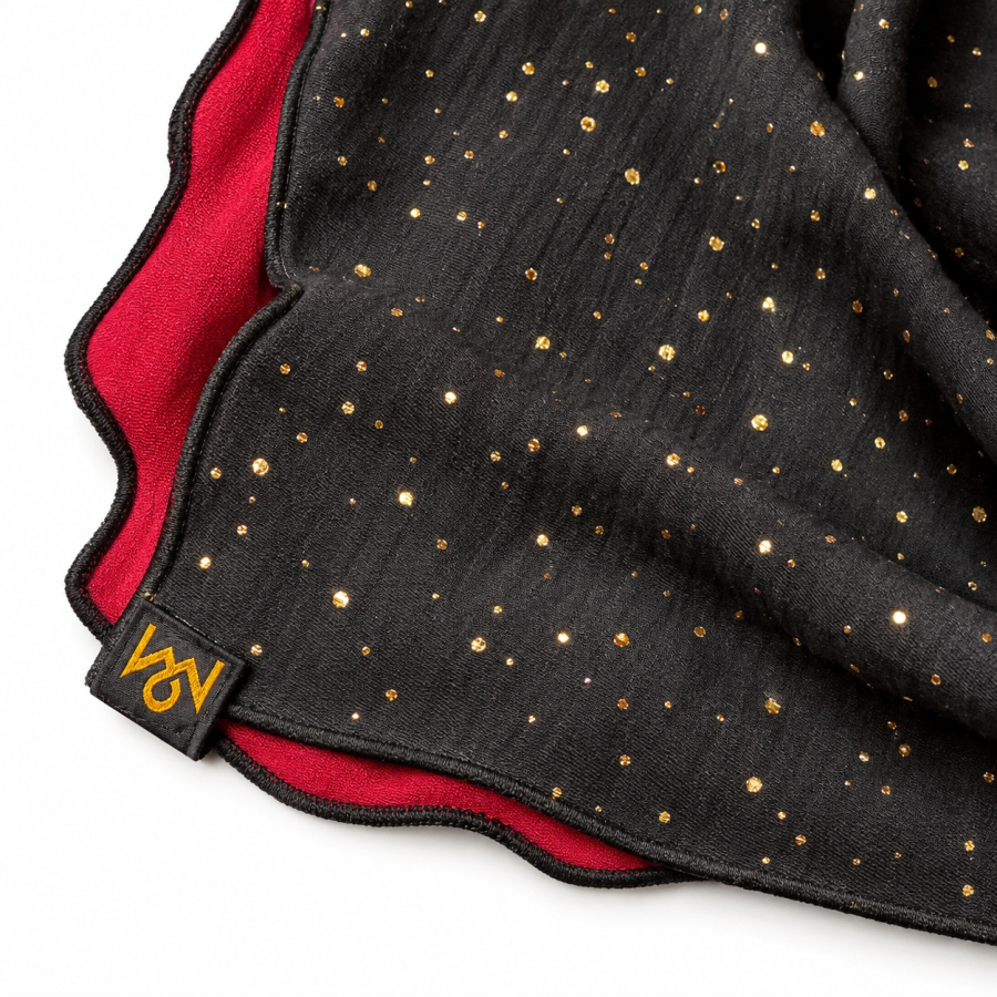 Preview: Detail des Baumwollmusselins mit Goldpunkten, schwarzem Rollsaum und OBERMUTTI-Label